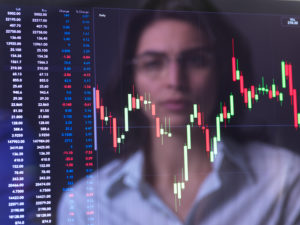 Female analyst viewing financial market data on a screen. Female analyst viewing financial market data on a screen.